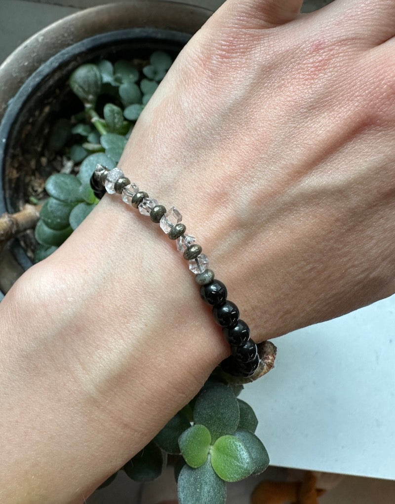 Hand wearing a beaded bracelet with a blurred background