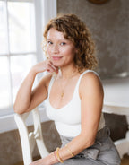 Woman sitting on a chair indoors with a neutral background