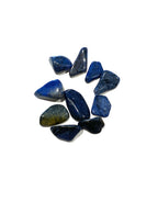 A picture of a few blue stones, dark in colour with a bit of yellowish hints. They are all slightly different. Tumbled in nature. 